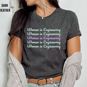 May include: A dark heather grey t-shirt with the text "Women in Engineering" repeated five times in a light purple colour.