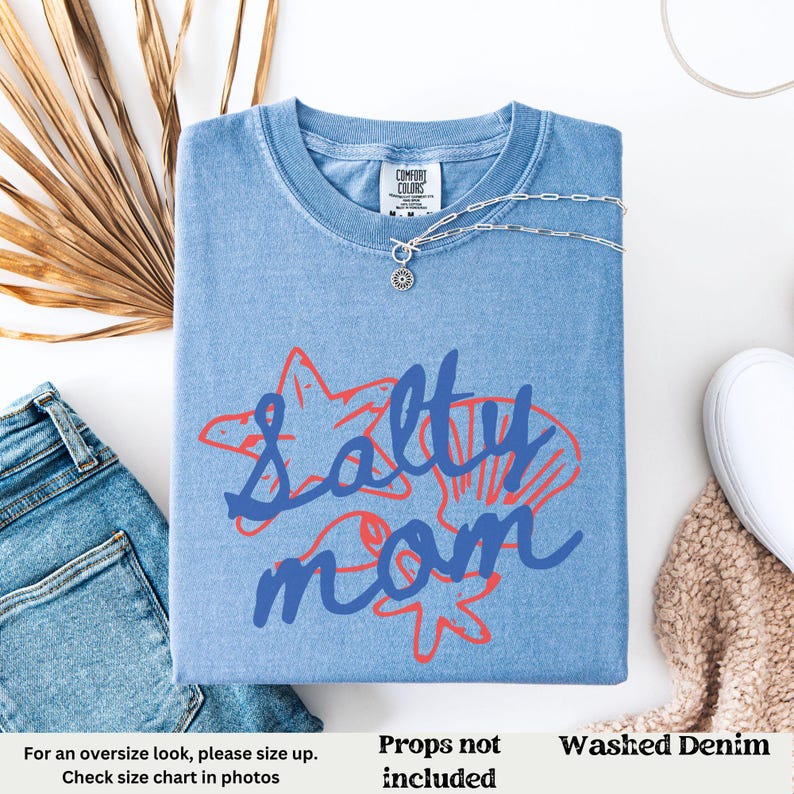 May include: A blue denim t-shirt with the text "Salty Mom" in blue and red lettering. The text is surrounded by a starfish and seashells.