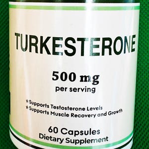 May include: White bottle of Turkesterone dietary supplement. The label includes the text "TURKESTERONE", "500 mg per serving", and "60 Capsules". The label also states that it supports testosterone levels and muscle recovery and growth.