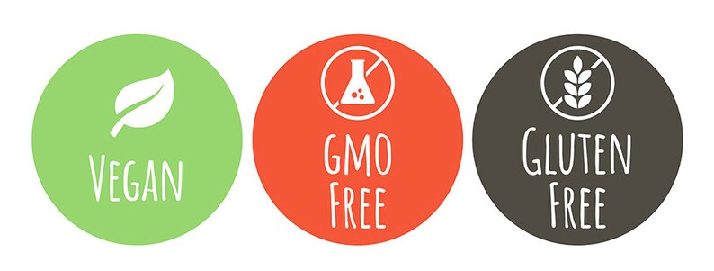 K&ouml;nnte beinhalten: Drei runde gr&uuml;ne, rote und graue Etiketten mit wei&szlig;em Text und Symbolen. Das gr&uuml;ne Etikett zeigt "VEGAN" mit einem wei&szlig;en Blattsymbol. Das rote Etikett zeigt "GMO FREE" mit einem wei&szlig;en Symbol eines Kolbens mit einem diagonalen Strich. Das graue Etikett zeigt "GLUTEN FREE" mit einem wei&szlig;en Symbol einer Weizen&auml;hre mit einem diagonalen Strich.
