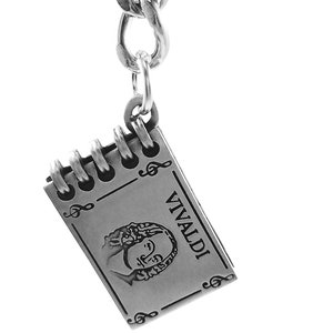 May include: Silver keychain featuring a small notebook charm with a portrait of composer Vivaldi and the word "VIVALDI" engraved on the front. The charm is attached to a silver chain.
