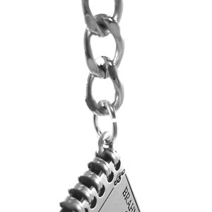 May include: A silver keychain with a silver chain and a silver charm in the shape of a book. The book has the word "BRAHMS" on the cover and a musical note design.
