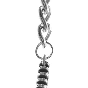 May include: A silver keychain with a book charm. The book charm is detailed with lines and has a silver chain attached to it.