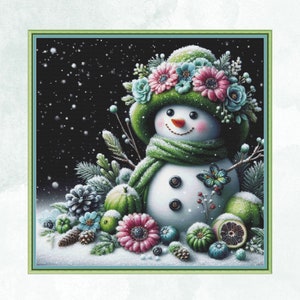 May include: A white snowman with a green hat and scarf, wearing a flower crown. The snowman is surrounded by green leaves, pine cones, and berries. The background is a dark blue with white snowflakes.