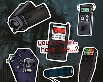 Könnte beinhalten: Eine Sammlung von Aufklebern mit Geisterjäger-Ausrüstung, darunter ein schwarzer HD-Camcorder, ein digitales Diktiergerät, ein Radio mit dem Text you.. c-can.. hear..me..?, eine sargförmige Spieluhr mit grünen Noten, eine Taschenlampe und ein EMF-Messgerät.