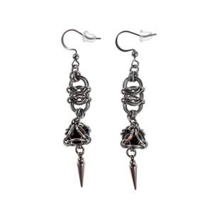 Op de afbeelding: Een paar zilverkleurige oorhangers. Elke oorbel heeft een kanten ontwerp met een donkerbruine steen en een zilveren spike hanger. De oorbellen hebben een haaksluiting.