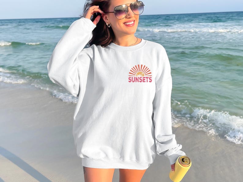 a woman standing on a beach next to the ocean