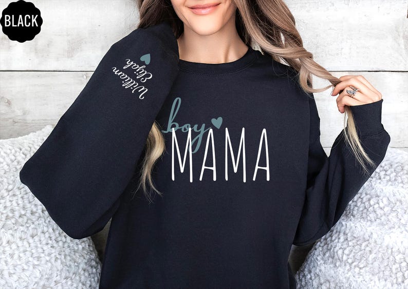 a woman wearing a black sweatshirt with the word mama printed on it