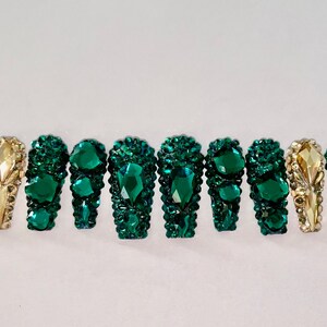 Op de afbeelding: Set van tien opdrukbare nagels in smaragdgroen en goud met strass.