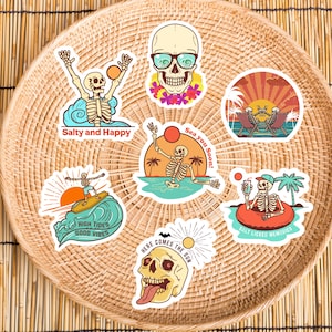 Peut inclure: Ensemble de 7 autocollants color&eacute;s repr&eacute;sentant des squelettes avec diff&eacute;rentes phrases sur le th&egrave;me de l'&eacute;t&eacute;, notamment "Salty and Happy", "High Tides Good Vibes", "Sea You Soon!" et "Here Comes the Sun".