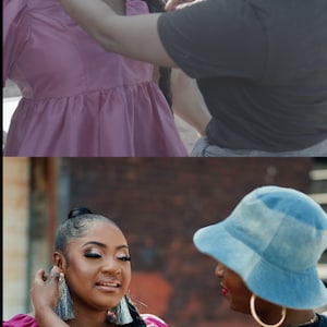 May include: Two women, one wearing a pink dress and the other wearing a black shirt and a blue hat, are adjusting each other's earrings. The woman in the pink dress has her hair pulled back in a ponytail.