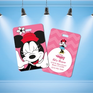 May include: Two pink luggage tags with a cartoon image of Minnie Mouse. One tag has a pink and white chevron pattern and the other has a solid pink background. The tag with the chevron pattern has the text "Disney WONDER ALICE BLANCO 1234 N. Main Street Miami, Fl 12345 (123) 456-7890".