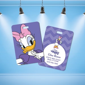 May include: Purple and white Disney Wonder luggage tag with a cartoon image of Daisy Duck. The tag has a chevron pattern and the text "Disney Wonder Eliana Blanco 1234 N. Main Street Miami, Fl 12345 (123) 456-7890".