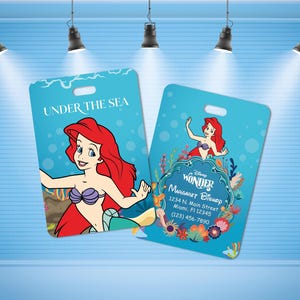 May include: Two blue luggage tags with a Disney Wonder logo and a mermaid illustration. The text on the tag reads "UNDER THE SEA" and "WONDER MARGARET BISHOP 1234 N. Main Street Miami, FI 12345 (123) 456-7890".