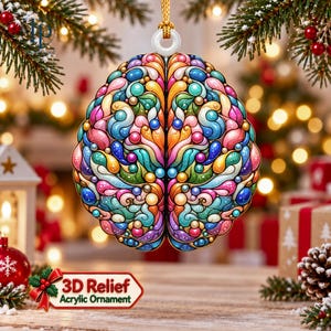 May include: A hanging ornament shaped like a human brain, featuring a colourful, swirling pattern of pink, blue, orange, purple, and green rounded shapes. The ornament has a white circular loop at the top with a gold string for hanging.