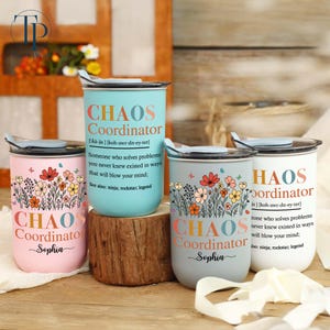 May include: Four stainless steel travel tumblers in pastel shades of pink, teal, and grey. Each tumbler is printed with the words "CHAOS Coordinator", a floral design, and a definition. The tumblers have a silver rim and a black lid.