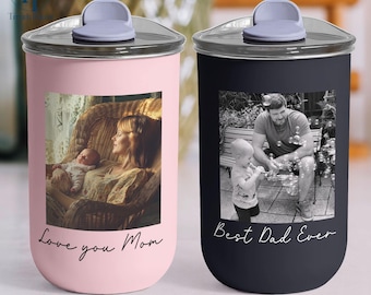 May include: Two stainless steel tumblers, one pink and one black, with silver lids. The pink tumbler has a photo of a mother and baby with the text "Love you Mom." The black tumbler has a photo of a father and child with the text "Best Dad Ever."