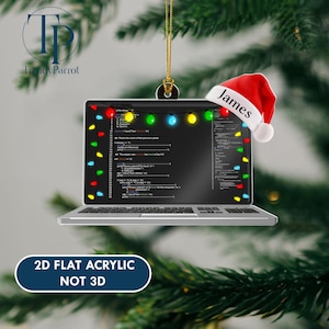 May include: A laptop-shaped Christmas ornament with a Santa hat that says "James." The laptop screen displays code and is decorated with colorful lights. The ornament is made of 2D flat acrylic.