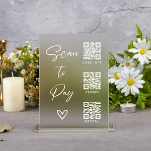 May include: A white acrylic sign with the text "Scan to Pay" and a heart symbol. The sign has three QR codes for Cash App, Venmo, and PayPal.