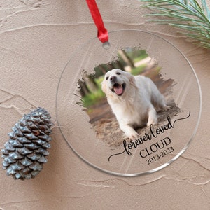 May include: A clear glass ornament with a white dog photo, a black brushstroke background, and the text "forever loved CLOUD 2013-2023".
