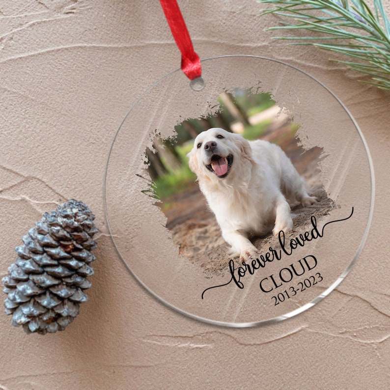 May include: A clear glass ornament with a white dog photo, a black brushstroke background, and the text "forever loved CLOUD 2013-2023".