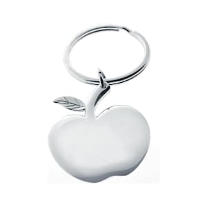 May include: A silver apple-shaped keychain with a key ring. The apple has a leaf and a stem.