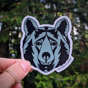 May include: A sticker featuring a blue and black bear head with the text "Northwest by Nature" at the bottom.