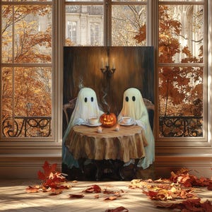 May include: A canvas print depicts two ghost figures seated at a table with teacups and a carved pumpkin. The artwork is set against a backdrop of a window with autumn foliage and a European-style building. The scene evokes a cozy, Halloween theme.