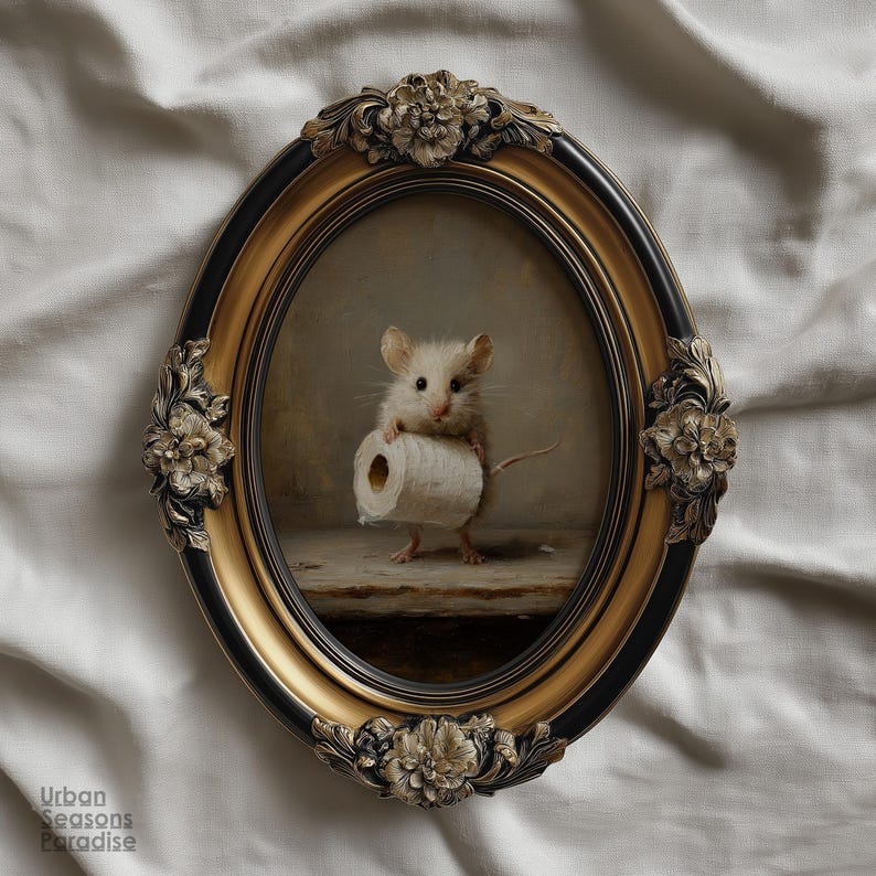 Op de afbeelding: Een ovaal wandkunstwerk met een schilderij van een kleine witte muis die een rol toiletpapier vasthoudt. Het kunstwerk is gevat in een sierlijke, zwart-gouden lijst met florale reli&euml;fdetails aan de boven-, onderkant en de zijkanten.