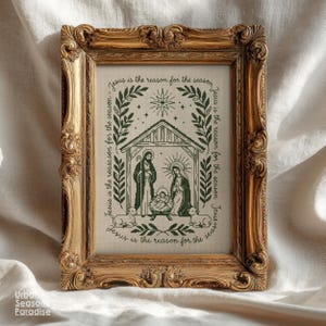 May include: A rectangular wall art piece in an ornate, antique gold-coloured frame. The print features a dark green line-art illustration of a nativity scene with the text "Jesus is the reason for the season" encircling the central image.