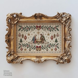 May include: A cross-stitch embroidery of a nativity scene featuring Mary, Joseph, and the infant Jesus, surrounded by Christmas ornaments, pine branches, and bells, encased in an ornate, antique-style gold frame with intricate scrollwork.