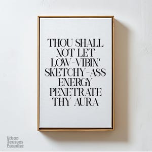 May include: A framed print with a white background and black text that reads "Thou shall not let low-vibin' sketchy-ass energy penetrate thy aura."