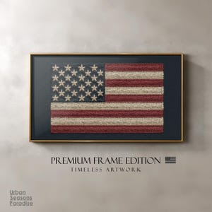 May include: Framed artwork featuring the American flag. The flag design has embroidered stars and stripes in red, white, and blue. The artwork is set against a dark background and framed in gold. The text "PREMIUM FRAME EDITION" and "TIMELESS ARTWORK" are displayed below the artwork.