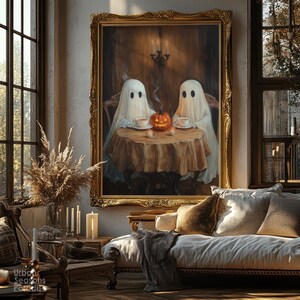 May include: A framed painting depicts two ghosts seated at a table with teacups and a carved pumpkin. The artwork is in a room with a couch, windows, and candles, creating a cozy, Halloween-themed atmosphere.