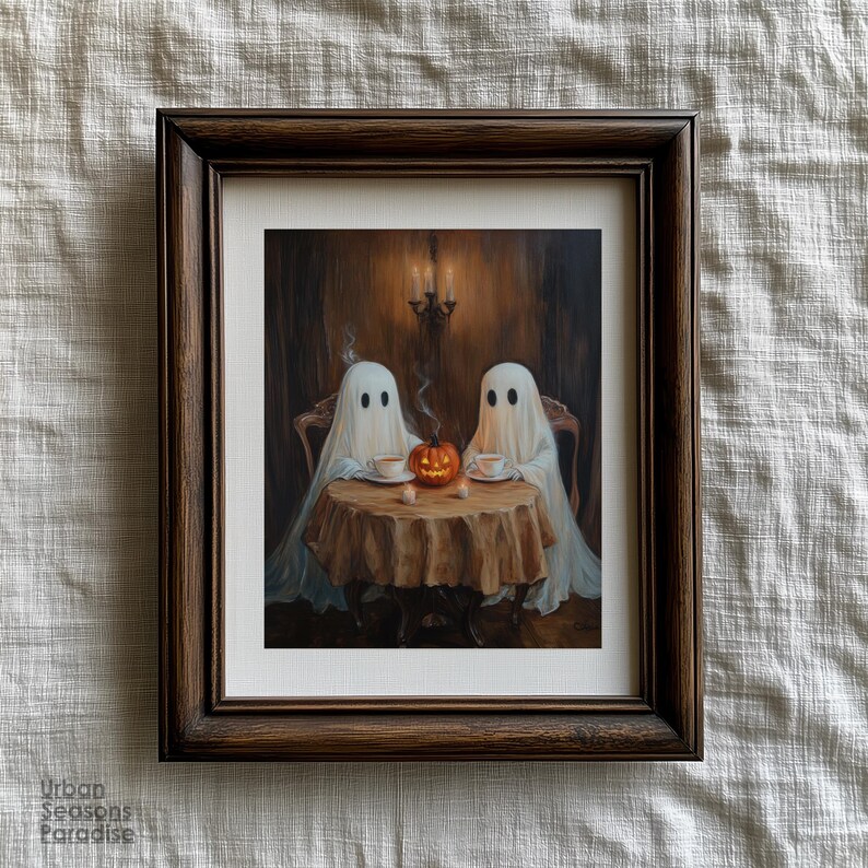 May include: A framed print depicts two ghosts seated at a table, enjoying tea with a carved pumpkin centerpiece. The artwork is set in a dimly lit room with a chandelier and a dark brown wooden frame. The print is a Halloween-themed artwork.