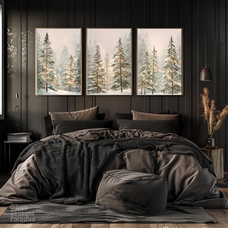 Puede incluir: Tres impresiones art&iacute;sticas enmarcadas que representan una escena de bosque invernal con &aacute;rboles cubiertos de nieve y una iluminaci&oacute;n suave. La obra de arte cuelga sobre una cama con ropa de cama gris oscuro, una manta de punto y un otom&aacute;n redondo. La habitaci&oacute;n tiene paneles de madera oscura.