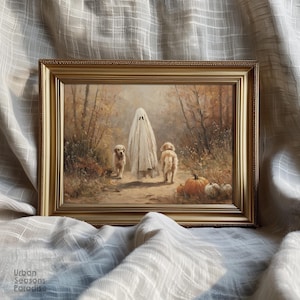 May include: A rectangular gold-toned frame containing a painting of a figure draped in a white sheet resembling a ghost walking on a path between two golden retriever dogs in an autumn forest with orange pumpkins resting on the ground nearby.