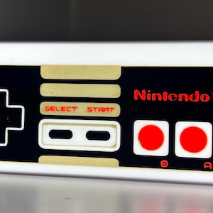 May include: A set of three ceramic mugs with a speckled, matte finish. The mugs are in shades of cream, light grey, and dark grey. Each mug has a simple, minimalist design, ideal for coffee or tea.