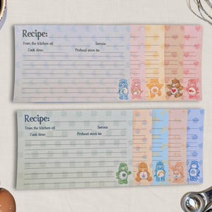 May include: Two recipe cards with a pastel color scheme and Care Bear illustrations. Each card has a section for recipe details and a decorative border with hearts and stars. The text "Recipe" is at the top of each card.