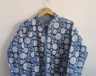 May include: A blue quilted jacket with a white floral pattern. The jacket has a mandarin collar and a button closure.