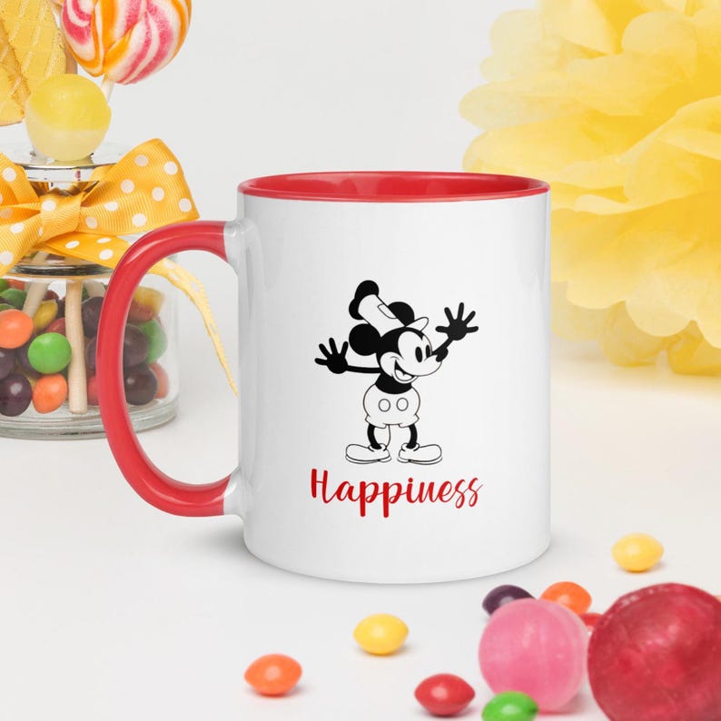 Może przedstawiać: Biały ceramiczny kubek z czerwonym wnętrzem i uchwytem. Kubek przedstawia czarno-białą ilustrację myszy z kresk&oacute;wki ze słowem "Happiness" w czerwonym skrypcie poniżej.
