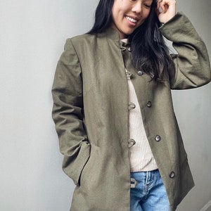May include: A green utility jacket with a mandarin collar and button closures. The jacket has a relaxed fit and is made of a soft, comfortable fabric.