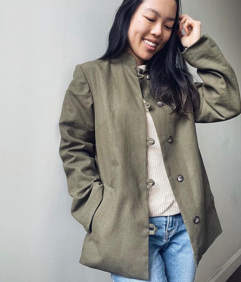 May include: A green utility jacket with a mandarin collar and button closures. The jacket has a relaxed fit and is made of a soft, comfortable fabric.