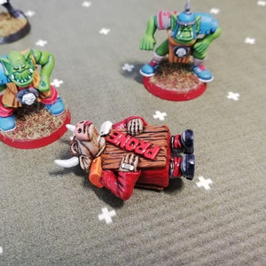Marqueur assommé Blood Bowl Big Guy avec trois variantes de tête