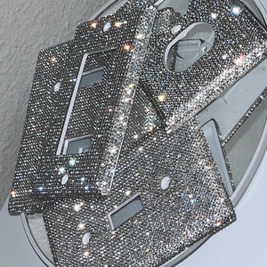 May include: Four silver light switch covers with a sparkly, diamond-like finish.