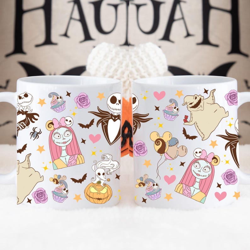 May include: Two white ceramic mugs featuring Halloween-themed illustrations. The designs include characters like Jack Skellington, Sally, and Oogie Boogie, along with cupcakes, bats, and stars. The background has the word "HALLOWEEN".