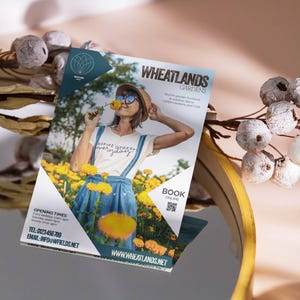 以下が含まれることがあります： Wheatlands Gardensのチラシ。庭のサービスを提供する会社です。チラシには、黄色の花畑にいる女性が写っており、シャツには「Inspire others everyday」と書かれています。チラシには、会社の連絡先とウェブサイトのアドレスも記載されています。