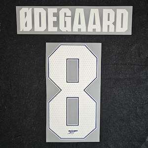 May include: White heat transfer vinyl for a jersey, featuring the name "ØDEGAARD" above the number "8". The number has a white dotted pattern, a navy blue outline, and the Arsenal logo at the bottom.