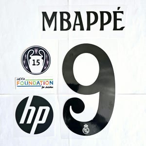 May include: Black and white iron-on letters spelling "MBAPPE" and the number "9" with a small white logo of a crown and a soccer ball. There are also three smaller iron-on patches: a UEFA Foundation for Children logo, a Champions League trophy logo, and an HP logo.