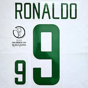 May include: Green and white iron-on patches with the name "RONALDO" and the number "9". The patches also include the FIFA World Cup logo and the text "2002 FIFA WORLD CUP KOREA JAPAN".